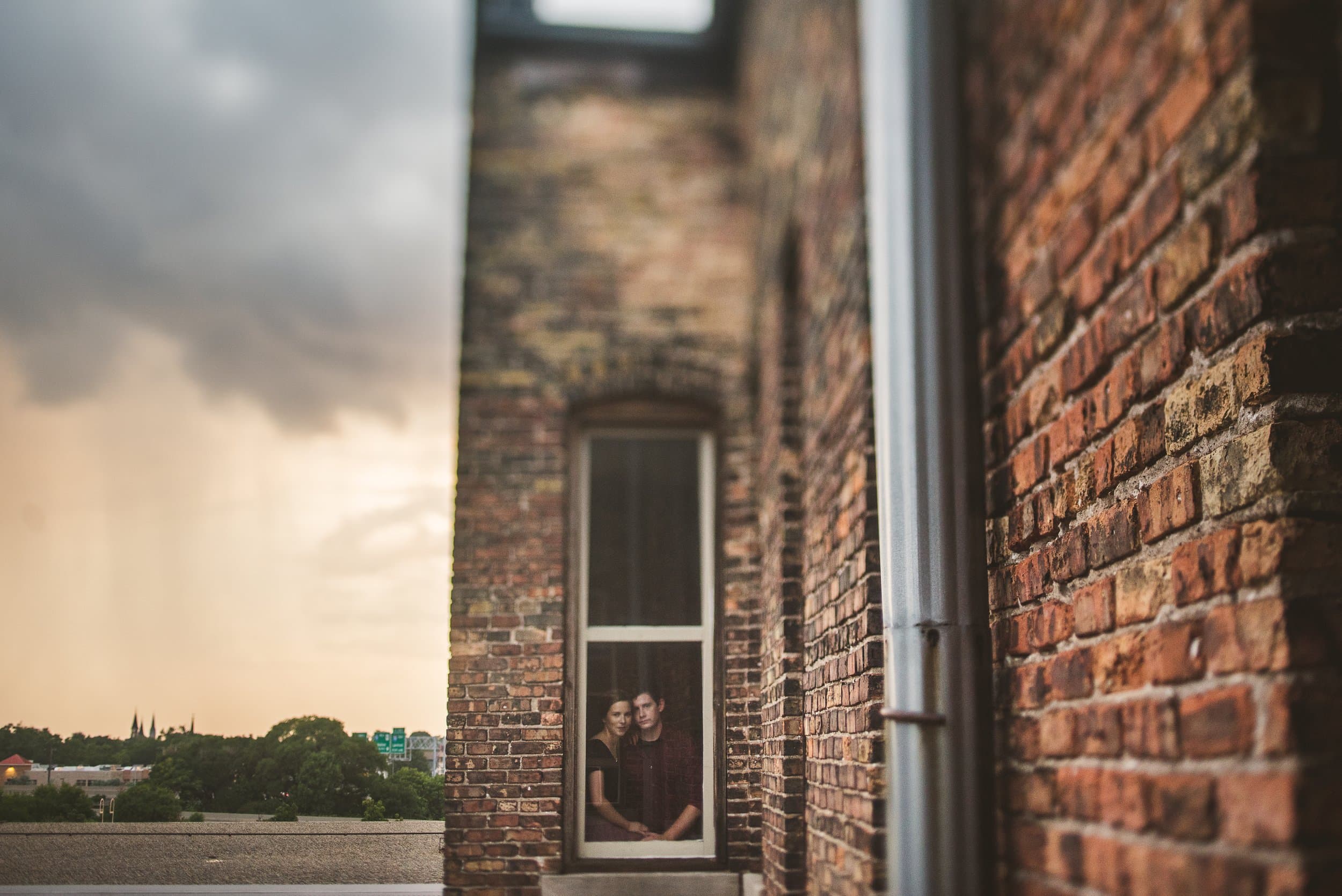 Storm clouds gathering over a brick building on a summer evening
