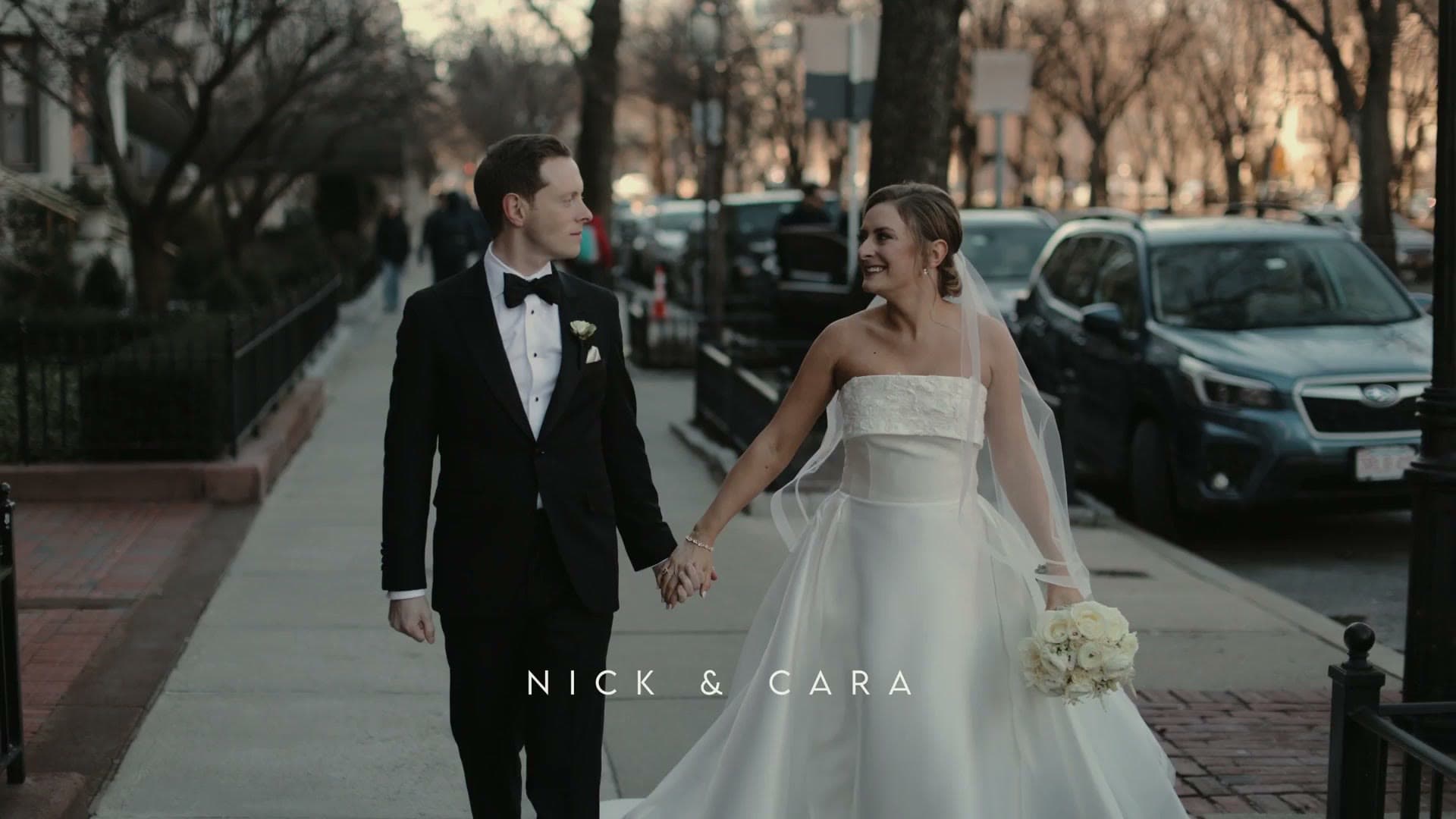 A bride and groom walking hand in hand along Commonwealth Avenue in Boston’s Back Bay under bare winter trees