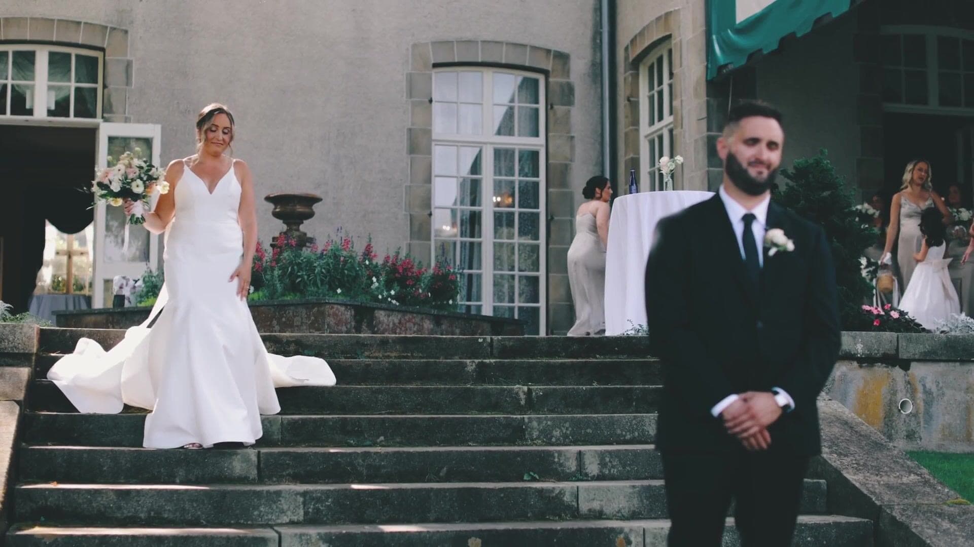 A bride walking down the stone steps from the terrace at Glen Manor House towards her groom for their first look