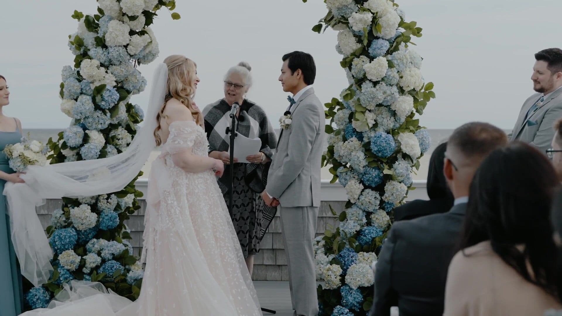 A bride’s veil lifted by the wind during an outdoor ceremony on the water at Wychmere Beach Club
